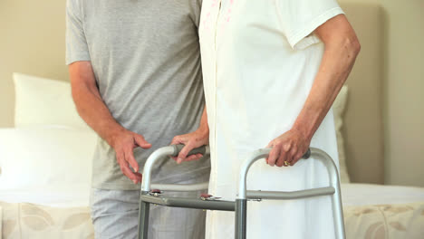 Male-nurse-helping-woman-to-walk-with-a-zimmer-frame