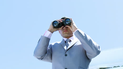 High-angle-of-businessman-looking-through-binoculars