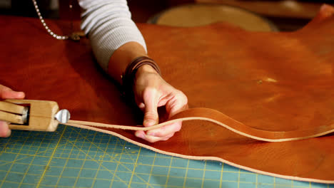 Close-up-of-craftswoman-cutting-leather