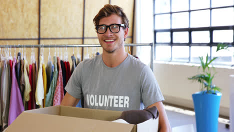 Voluntario-Sosteniendo-Caja-De-Donación-De-Ropa-En-La-Oficina.