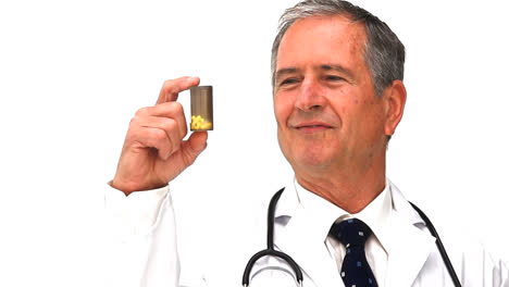 Elderly-doctor-holding-yellow-pills
