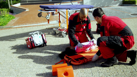 Paramedics-putting-injured-girl-onto-a-backboard