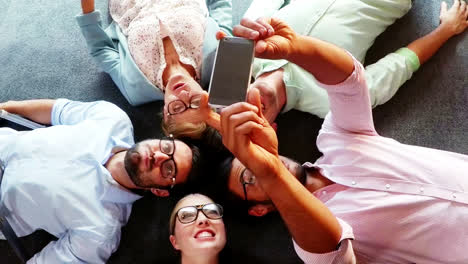 Group-of-business-executives-taking-selfie-from-mobile-phone