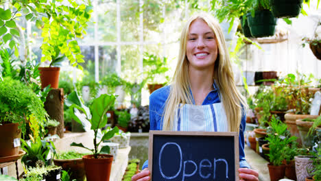 Portrait-of-beautiful-woman-holding-open-sign