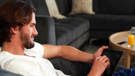 Man-using-digital-tablet-in-living-room