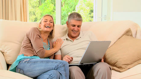 Couple-on-sofa-enjoying-something-on-laptop
