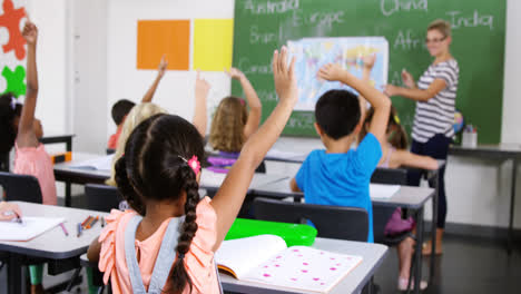 School-kids-raising-hand-in-classroom