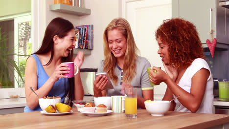 Friends-laughing-while-eating-breakfast-together