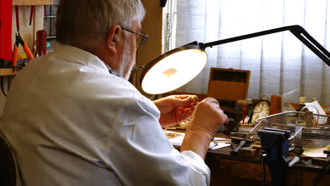 Rear-view-of-horologist-repairing-a-watch