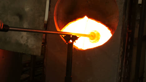 Glassblower-heating-a-glass-in-furnace