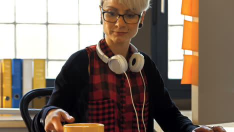 Female-graphic-designer-working-on-computer-while-having-black-coffee