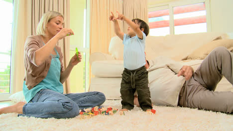 Mother-blowing-bubbles-while-baby-tries-to-catch-them