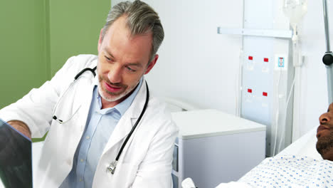 Männlicher-Arzt-Bespricht-Röntgenaufnahme-Mit-Patient