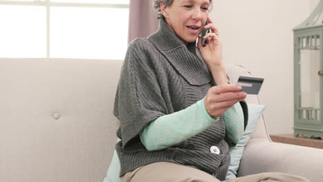 Woman-using-her-card-to-buy-with-telephone