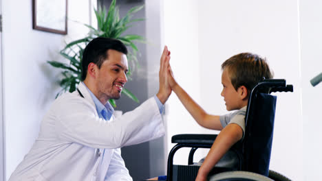Doctor-giving-high-five-to-disable-boy
