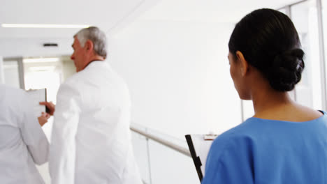 Doctors-and-nurse-running-in-passageway-of-hospital