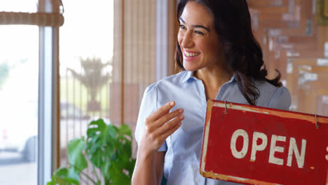 Smiling-woman-holding-an-open-sign