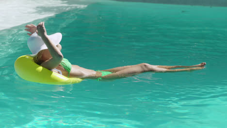 Woman-with-inflatable-ring-in-swimming-pool