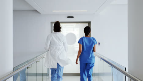 Doctor-and-nurse-running-in-passageway-of-hospital