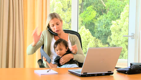 Junge-Mutter-Versucht,-Büroarbeit-Mit-Widerspenstigem-Baby-Auf-Dem-Schoß-Zu-Erledigen