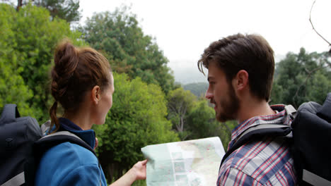 Vista-Trasera-De-Excursionistas-Mirando-Un-Mapa-Con-Una-Brújula