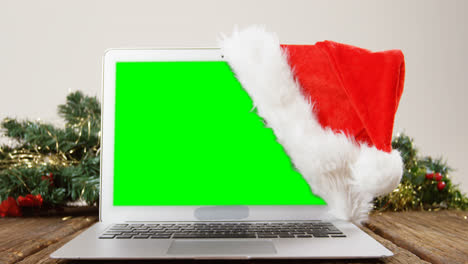 Laptop-Mit-Weihnachtsmütze-Auf-Einem-Brett