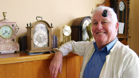 Portrait-of-smiling-horologist-adjusting-watch