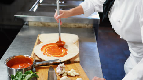 Chef-applying-sauce-on-flat-bread