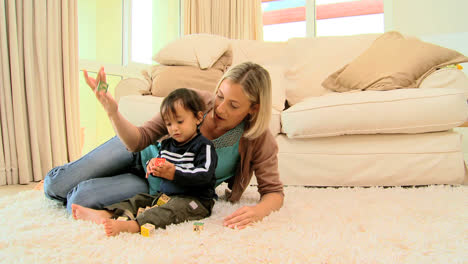 Mother-with-little-boy-playing-alphabet-blocks-on-carpet