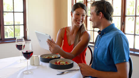 Lächelndes-Paar-Mit-Einem-Digitalen-Tablet-Im-Restaurant