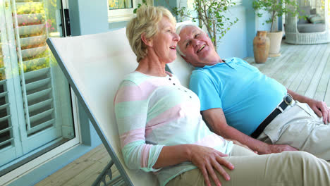 Senior-couple-sitting-on-deck-chairs