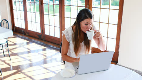 Hermosa-Mujer-Tomando-Café-Y-Usando-Una-Computadora-Portátil-