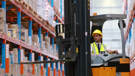 Male-warehouse-worker-using-forklift-truck
