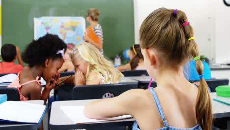 Schoolgirl-doing-homework-in-classroom