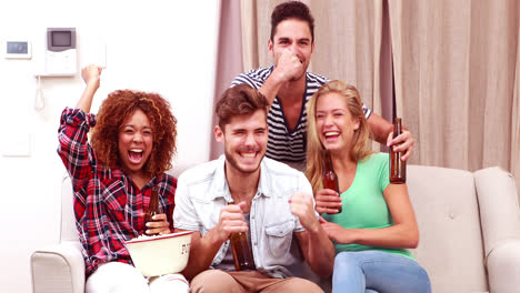 Lächelnde-Freunde-Vor-Dem-Fernseher,-Während-Sie-Popcorn-Essen-Und-Bier-Trinken