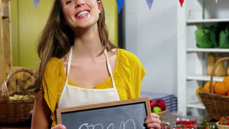 Portrait-of-female-staff-holding-a-open-sign