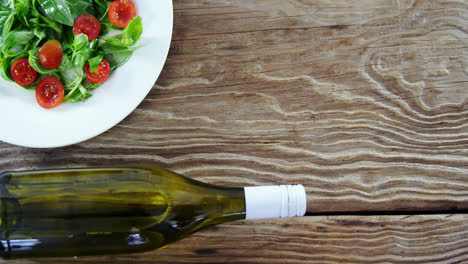 Salad-with-bottle-on-wooden-table