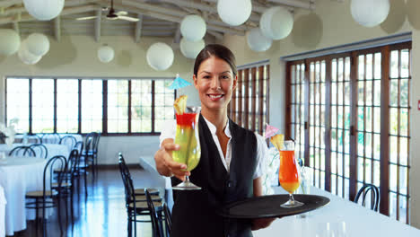 Smiling-waitress-offering-a-cocktail-drink