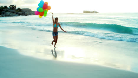 Woman-running-on-beach-with-balloons