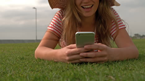 Smiling-woman-using-smartphone-at-park