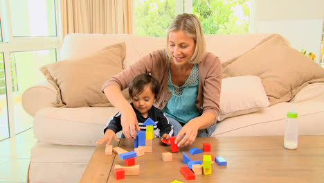 Young-mother-playing-with-her-baby-with-building-blocks