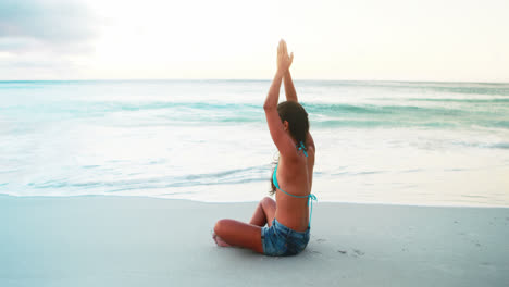 Woman-performing-yoga-on-beach