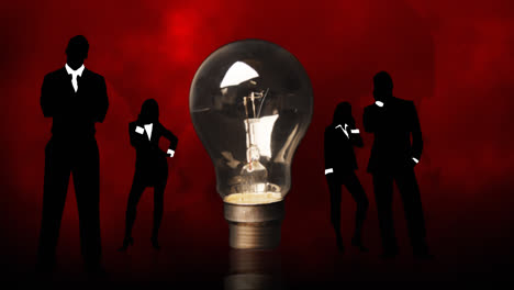 Business-people-silhouettes-around-a-lightbulb.-Concept-of-clever