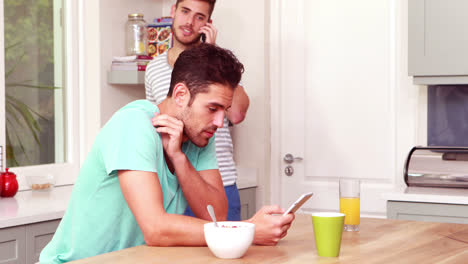 Freunde-Lachen,-Während-Sie-In-Der-Küche-Smartphones-Benutzen