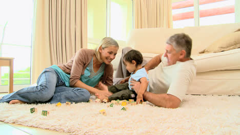 Eltern-Spielen-Mit-Baby-Auf-Wohnzimmerteppich
