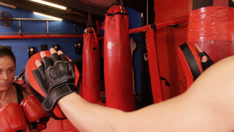 Female-boxer-practicing-with-trainer