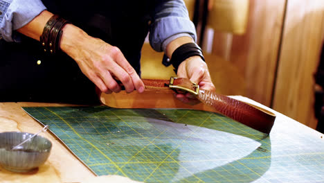 Mid-section-of-craftswoman-making-leather-belt