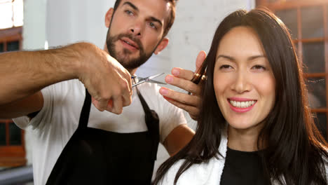 Woman-getting-his-hair-trimmed-with-scissor