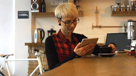 Weibliche-Führungskraft-Mit-Digitalem-Tablet-Beim-Kaffeetrinken