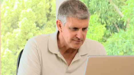 Mature-man-working-on-his-laptop-and-then-posing-